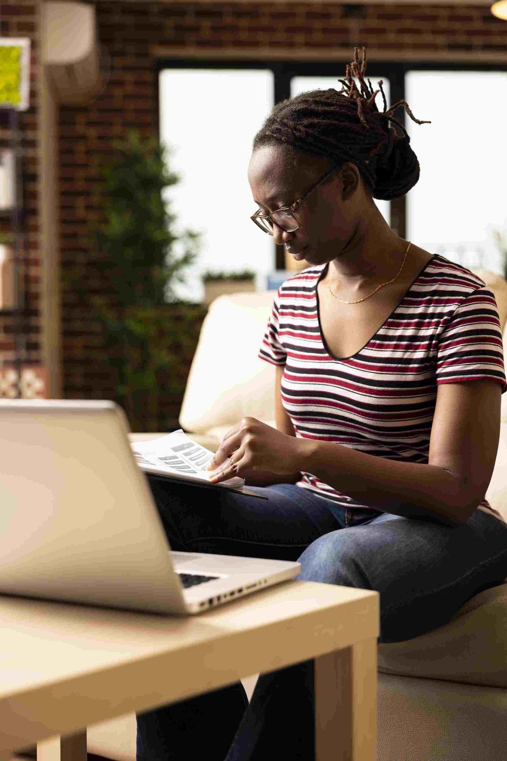A person at home reading through a stack of documents